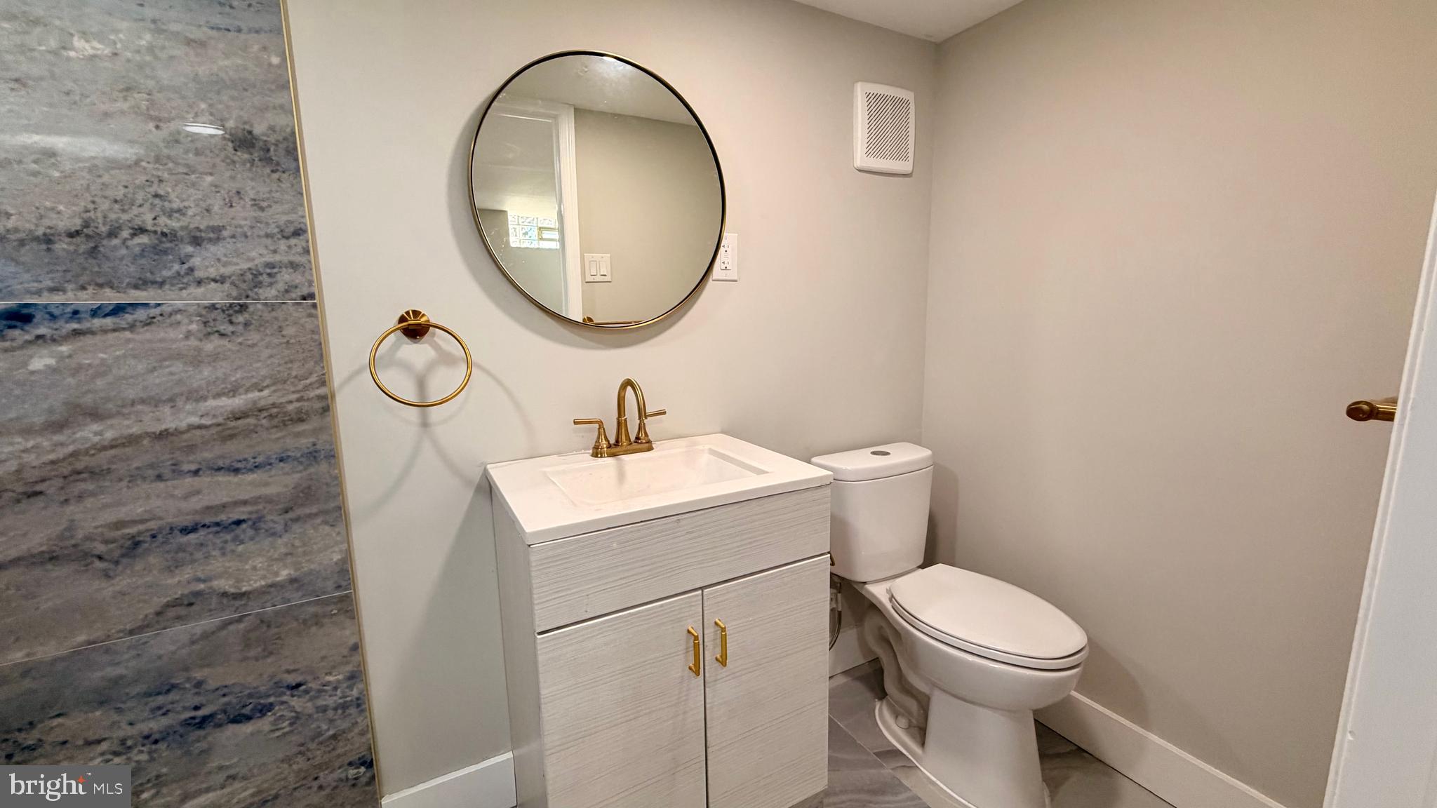 7219 Saul Street Philadelphia, PA 19149 - Photo 23 of 24 a bathroom with a toilet sink and mirror