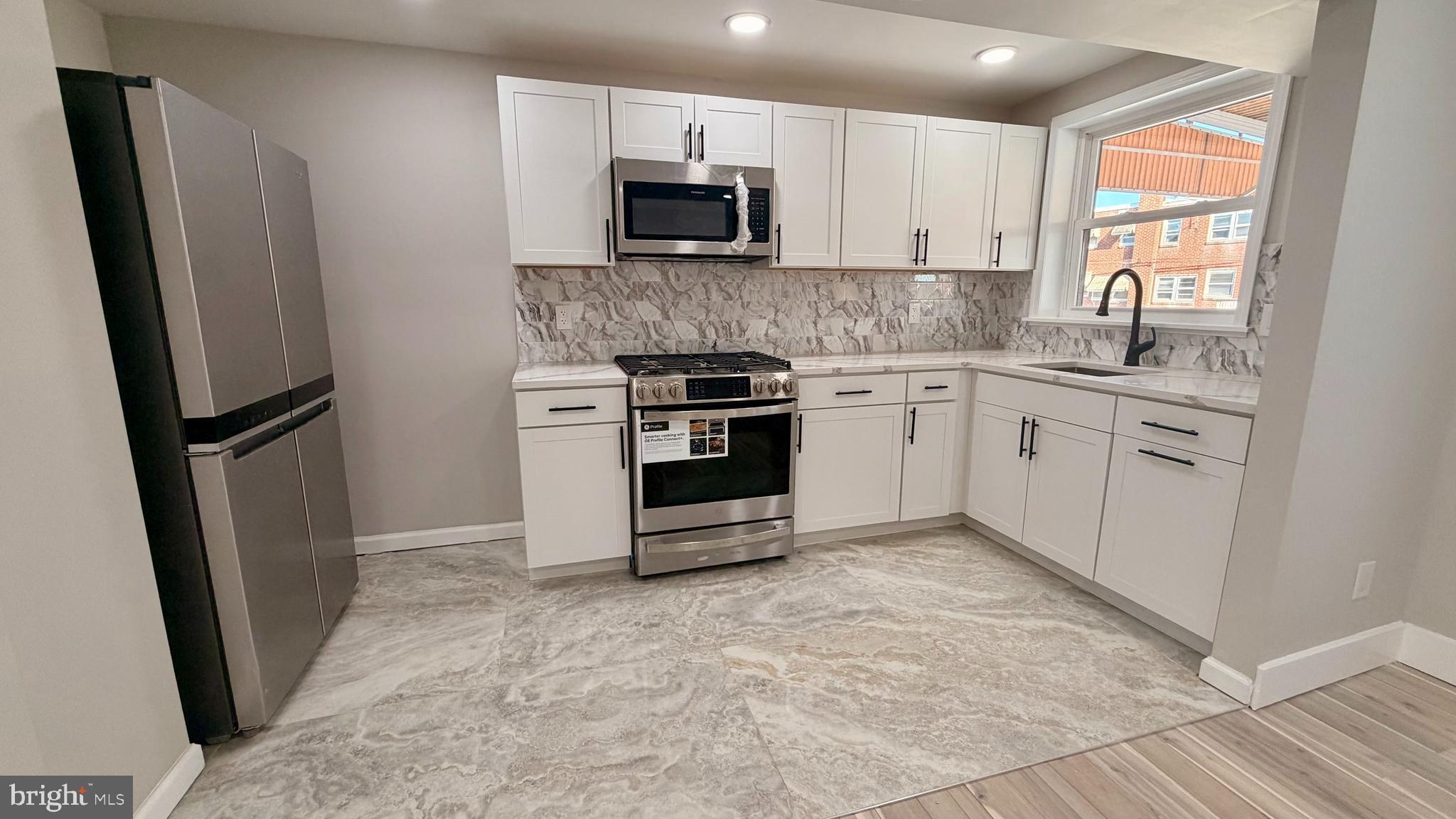 7219 Saul Street Philadelphia, PA 19149 - Photo 7 of 24 a kitchen with stainless steel appliances granite countertop a stove a refrigerator and a sink