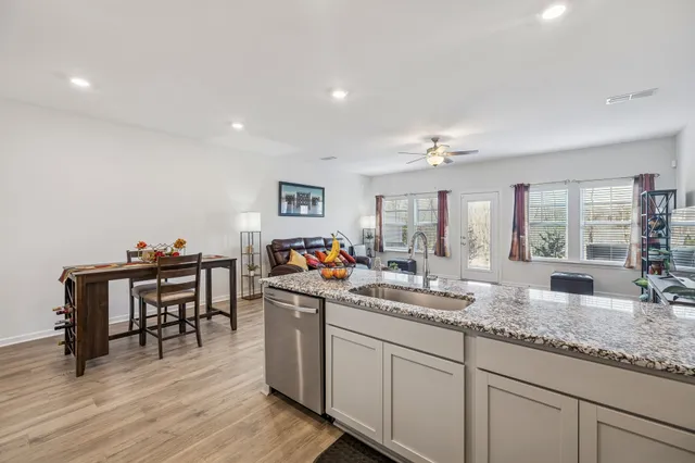 a very nice looking living room with granite countertop a couch and a wooden floor