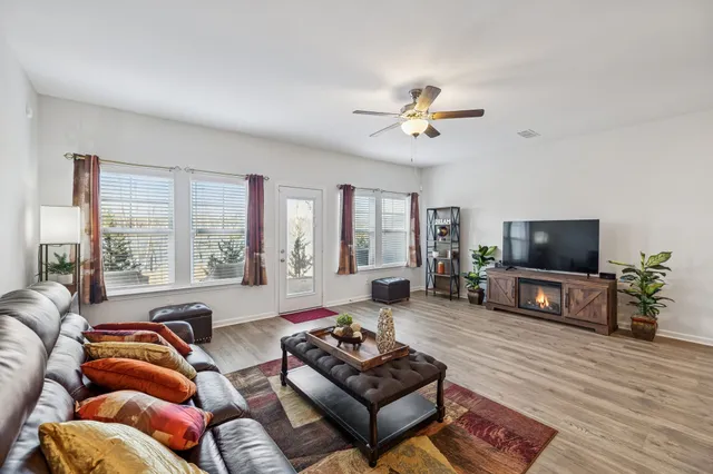 a living room with furniture and a flat screen tv with wooden floor