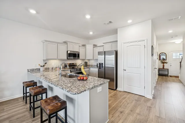 a kitchen with refrigerator cabinets and wooden floor