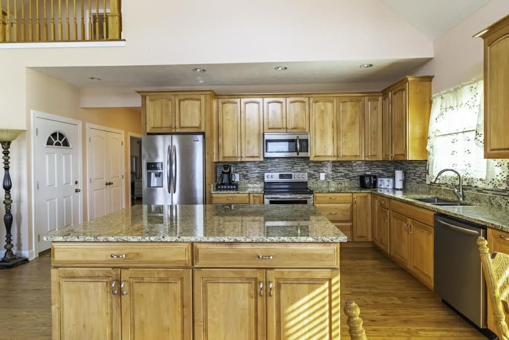 637 River Road Clifton, TN 38425 - Photo 3 of 19 a kitchen with kitchen island granite countertop a sink cabinets and stainless steel appliances