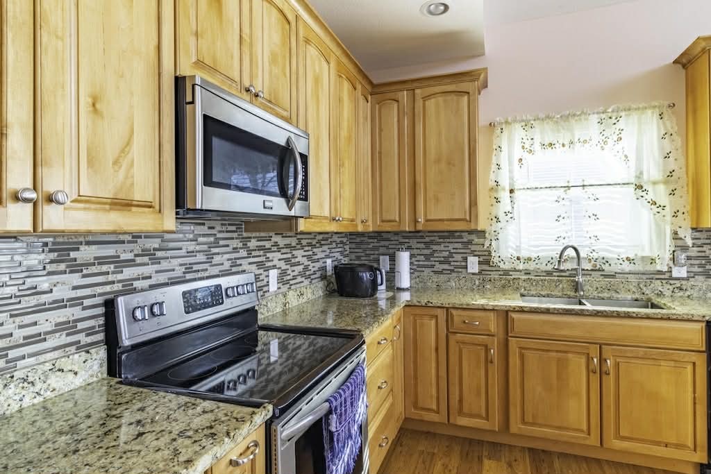 637 River Road Clifton, TN 38425 - Photo 4 of 19 a kitchen with stainless steel appliances granite countertop a stove a sink and a microwave