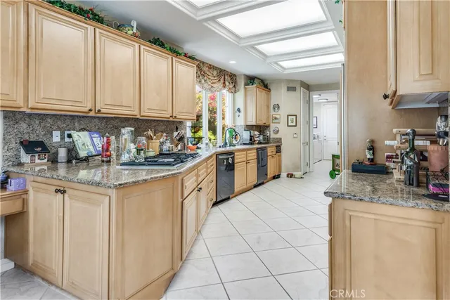 a kitchen with stainless steel appliances granite countertop a stove a sink and white cabinets