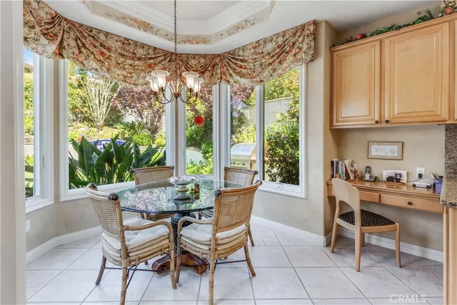 a dining room with wooden floor a chandelier a glass table and chairs