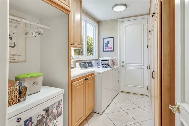 a utility room with cabinets washer and dryer