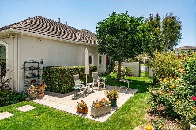 a view of a chair and table in backyard of the house
