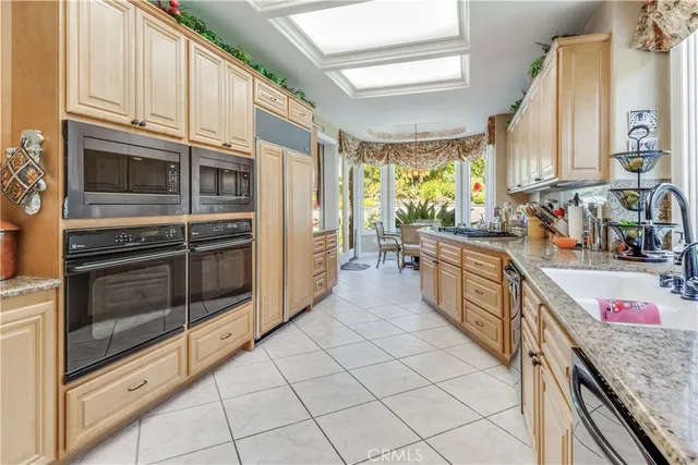 a kitchen with stainless steel appliances kitchen island granite countertop a sink and cabinets