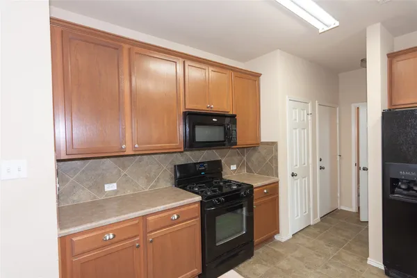 a kitchen with a refrigerator stove and cabinets