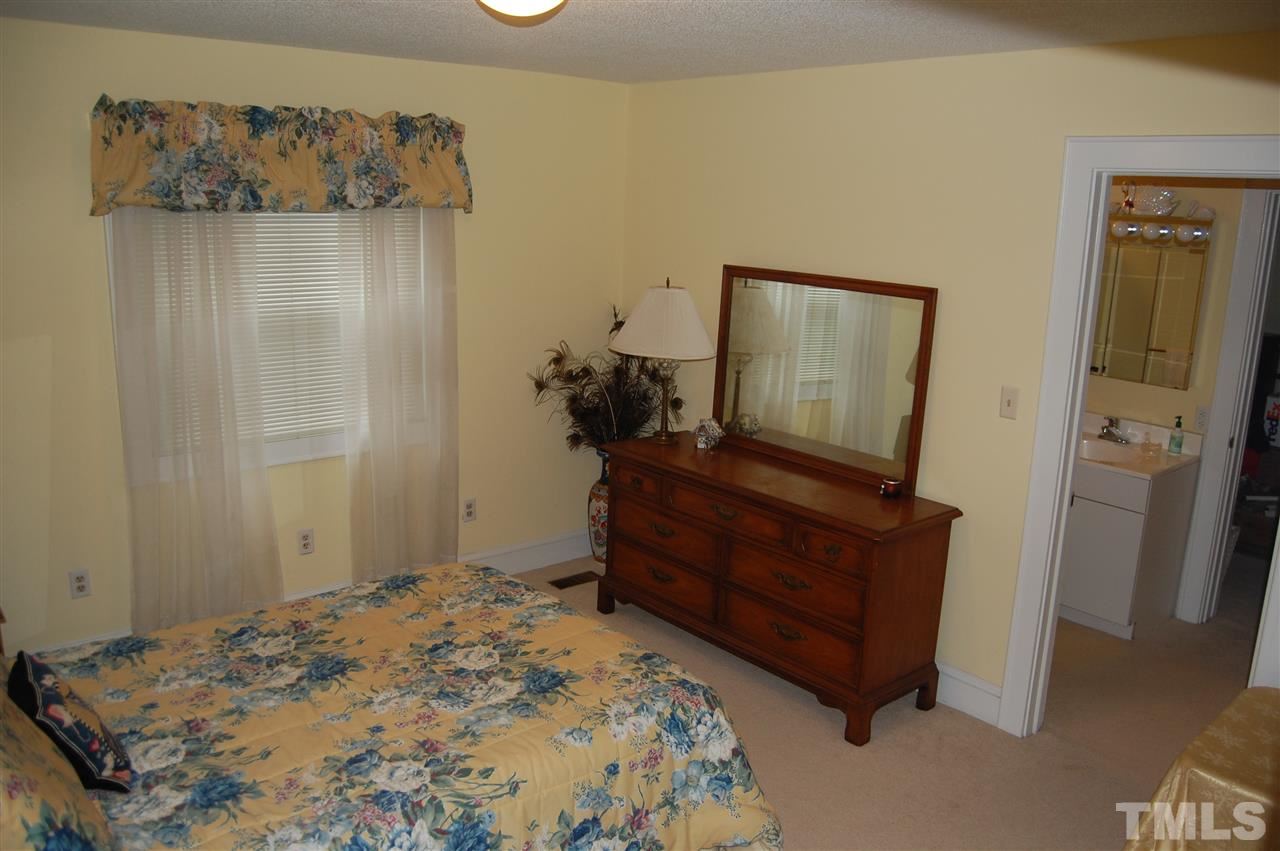 6740 Good Life Road Wendell, NC 27591 - Photo 16 of 25 a bedroom with a bed and a mirror on dresser