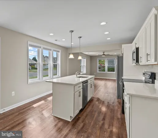 a kitchen with stove and wooden floor