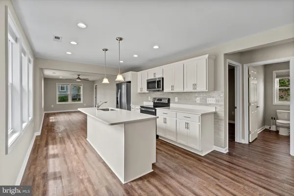 a kitchen with stainless steel appliances sink stove refrigerator and cabinets