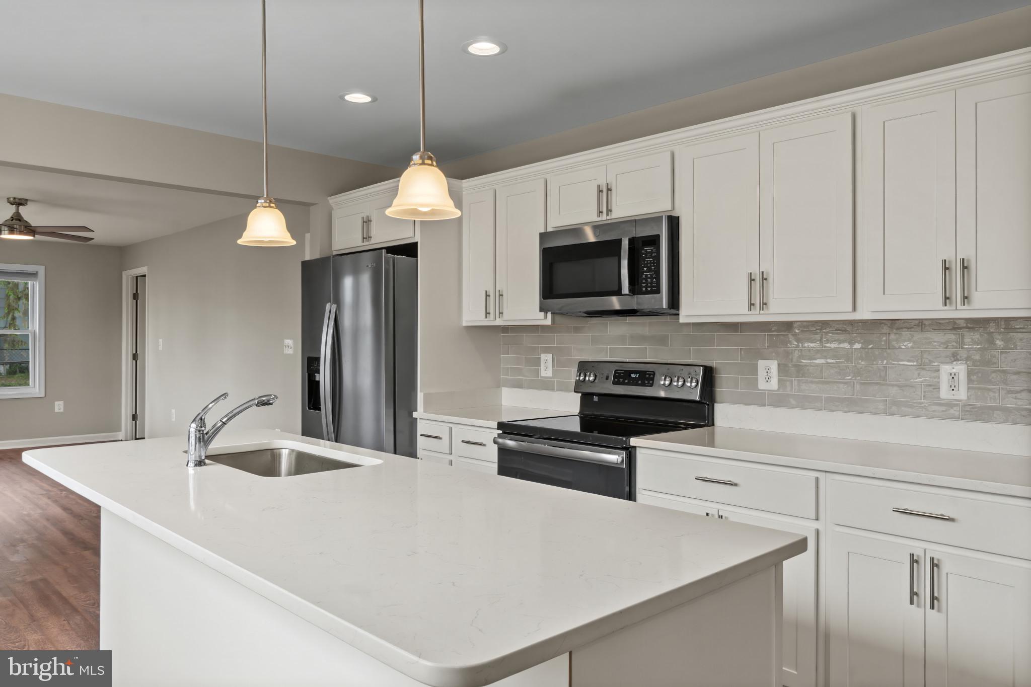14 Montrose Road Pasadena, MD 21122 - Photo 10 of 19 a kitchen with stainless steel appliances a stove a sink a microwave and cabinets