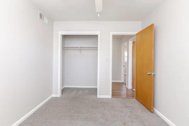 an empty room with windows and closet
