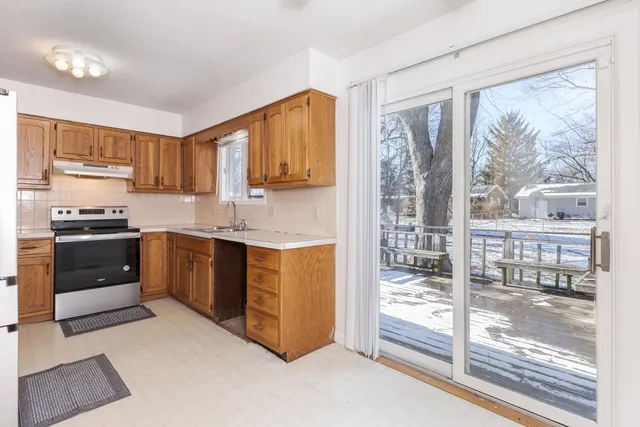 a kitchen with stainless steel appliances granite countertop a stove a sink and a refrigerator
