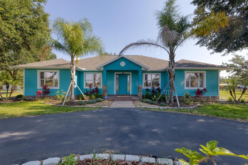 a view of a house with table and chairs in a yard