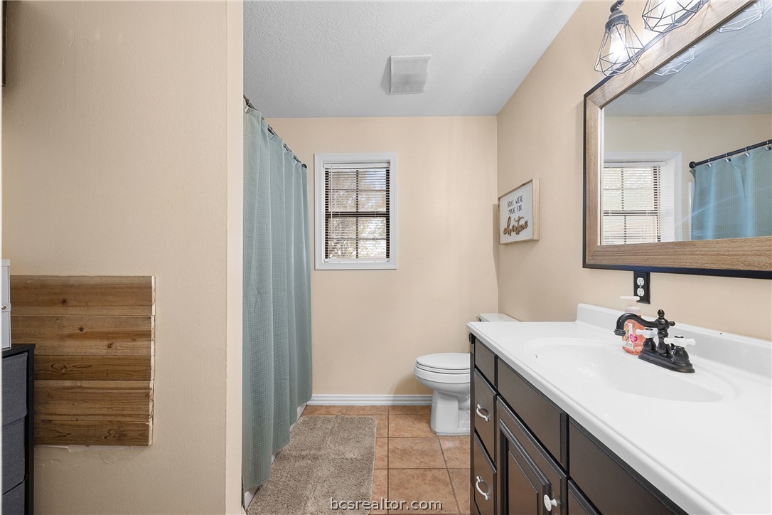 3540 Fisher Ranch Road Bryan, TX 77808 - Photo 16 of 36 a bathroom with a sink a toilet and mirror