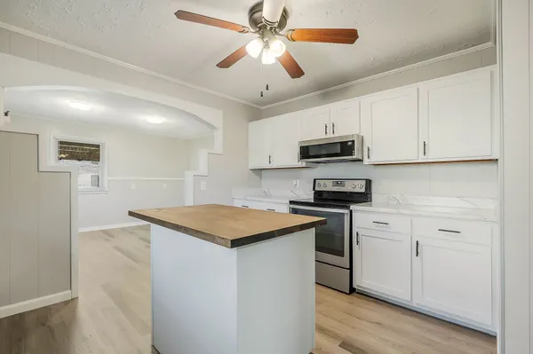 a kitchen with stainless steel appliances granite countertop a stove sink microwave and refrigerator