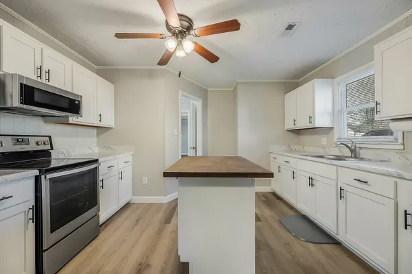 a kitchen with stainless steel appliances granite countertop a stove sink microwave and cabinets