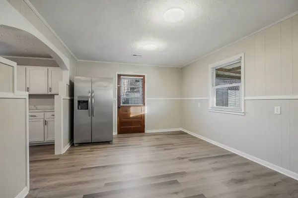 a view of kitchen with refrigerator and wooden floor