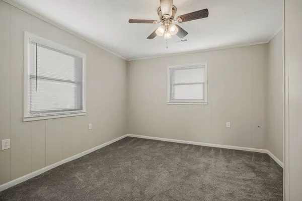 an empty room with a window and a fan