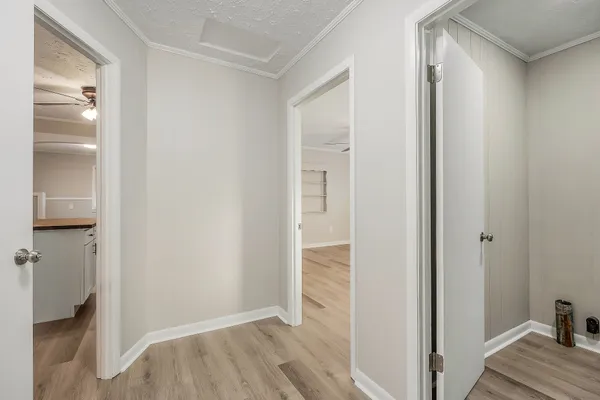 a view of hallway with closet and wooden floor