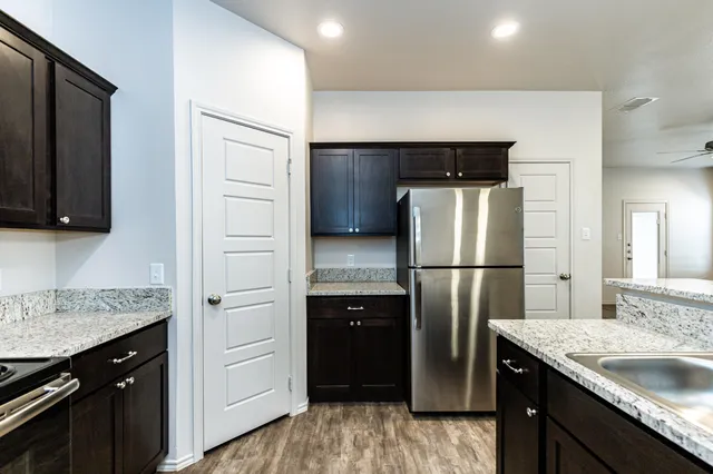 a kitchen with a refrigerator sink and cabinets