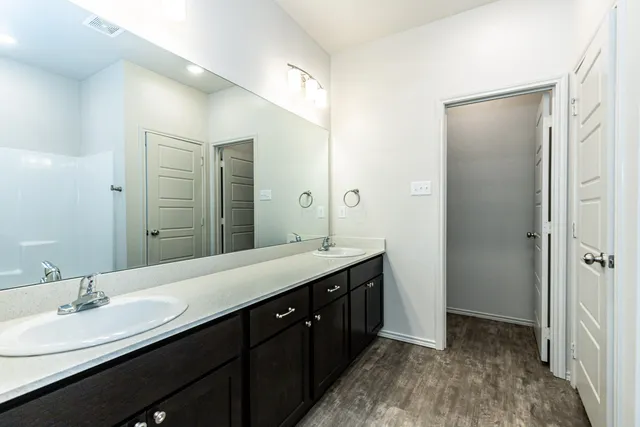a bathroom with a double vanity sink and a mirror