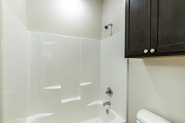 a bathroom with a shower a toilet and a sink