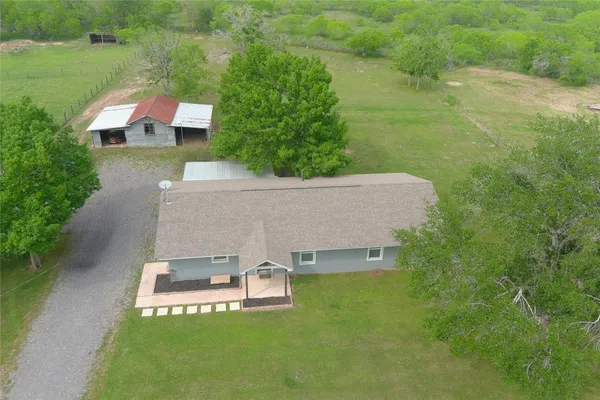 an aerial view of a house with swimming pool and garden