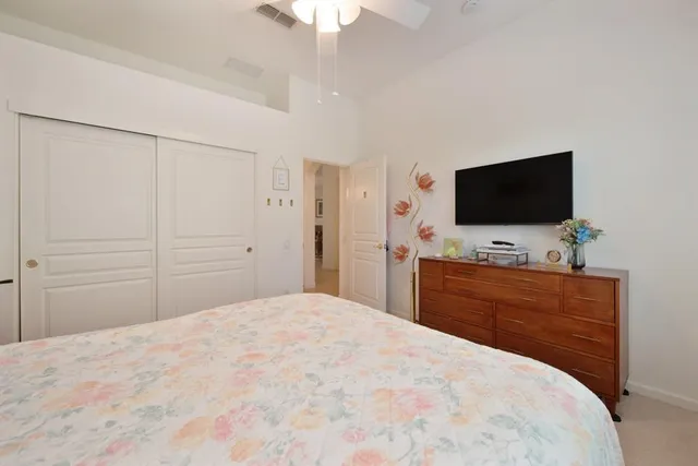 a bedroom with a bed window and a flat screen tv