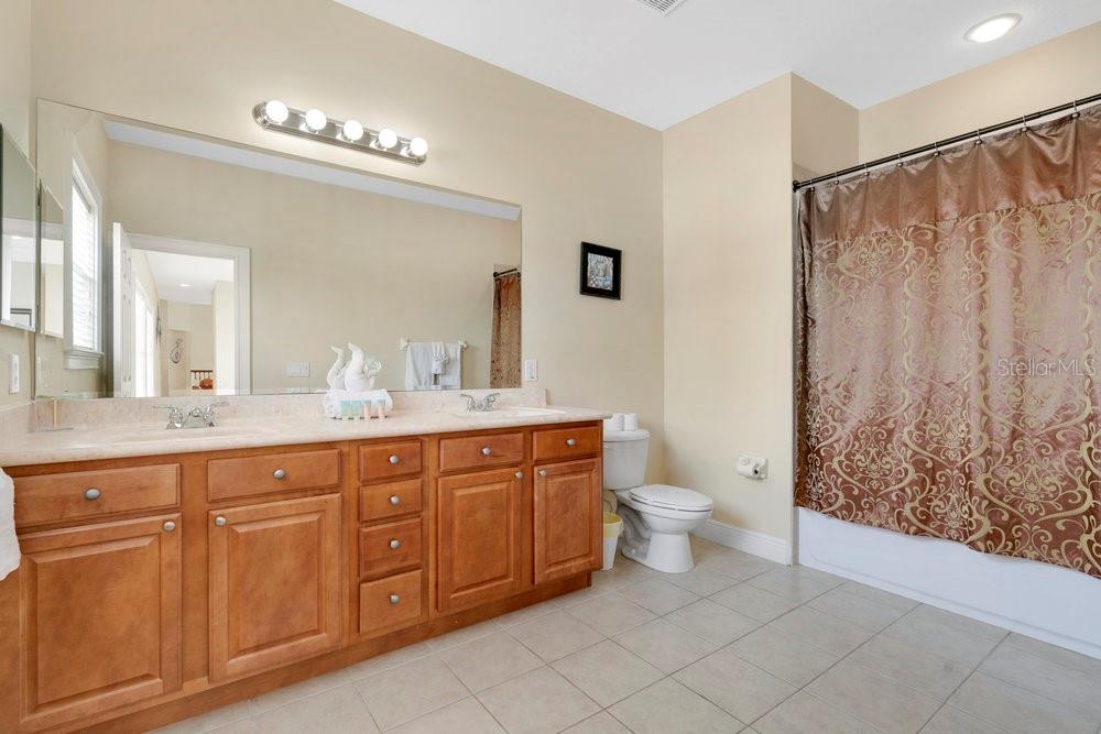 7404 Oconee Street Reunion, FL 34747 - Photo 15 of 87 a spacious bathroom with a double vanity sink toilet and a mirror