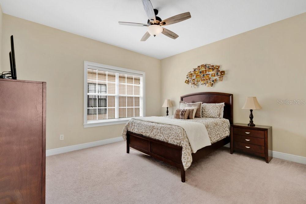 7404 Oconee Street Reunion, FL 34747 - Photo 17 of 87 a spacious bedroom with a bed painting on wall and a large window