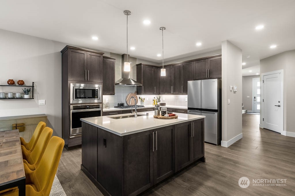 22905 20th Place West Bothell, WA 98021 - Photo 11 of 26 a kitchen with stainless steel appliances granite countertop a sink a stove a refrigerator and chairs