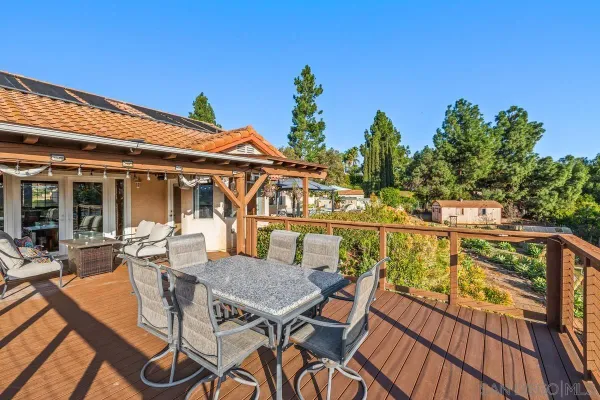 a view of a patio with table and chairs with wooden floor and fence