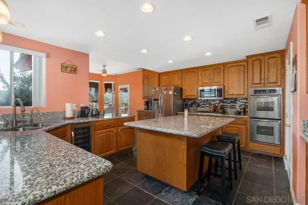 a kitchen with stainless steel appliances granite countertop sink wooden cabinets and a granite counter tops