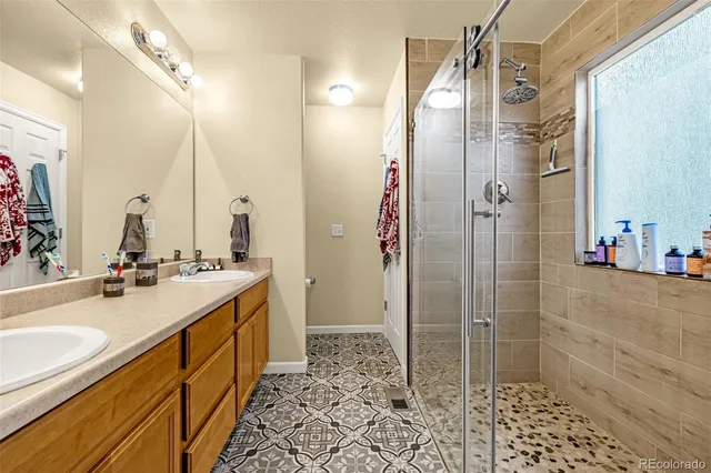 a bathroom with a double vanity sink toilet mirror and shower