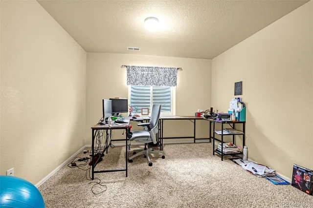 a view of a workspace with furniture and a window