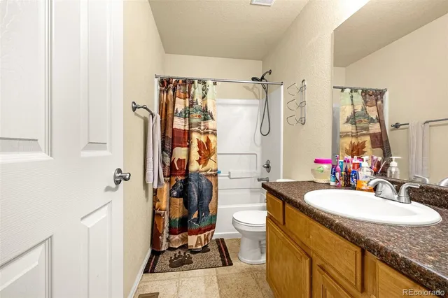 a bathroom with a granite countertop sink a mirror and a shower