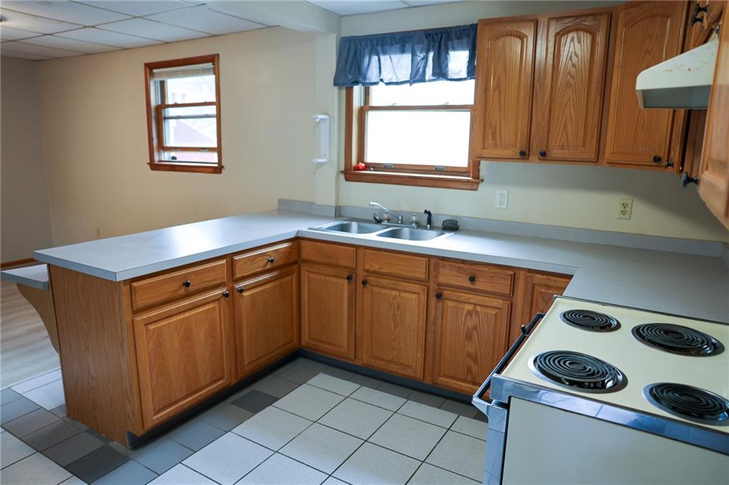 221 2nd Street, Unit 5 Smithton, PA 15479 - Photo 4 of 13 a kitchen with stainless steel appliances granite countertop a sink stove and cabinets