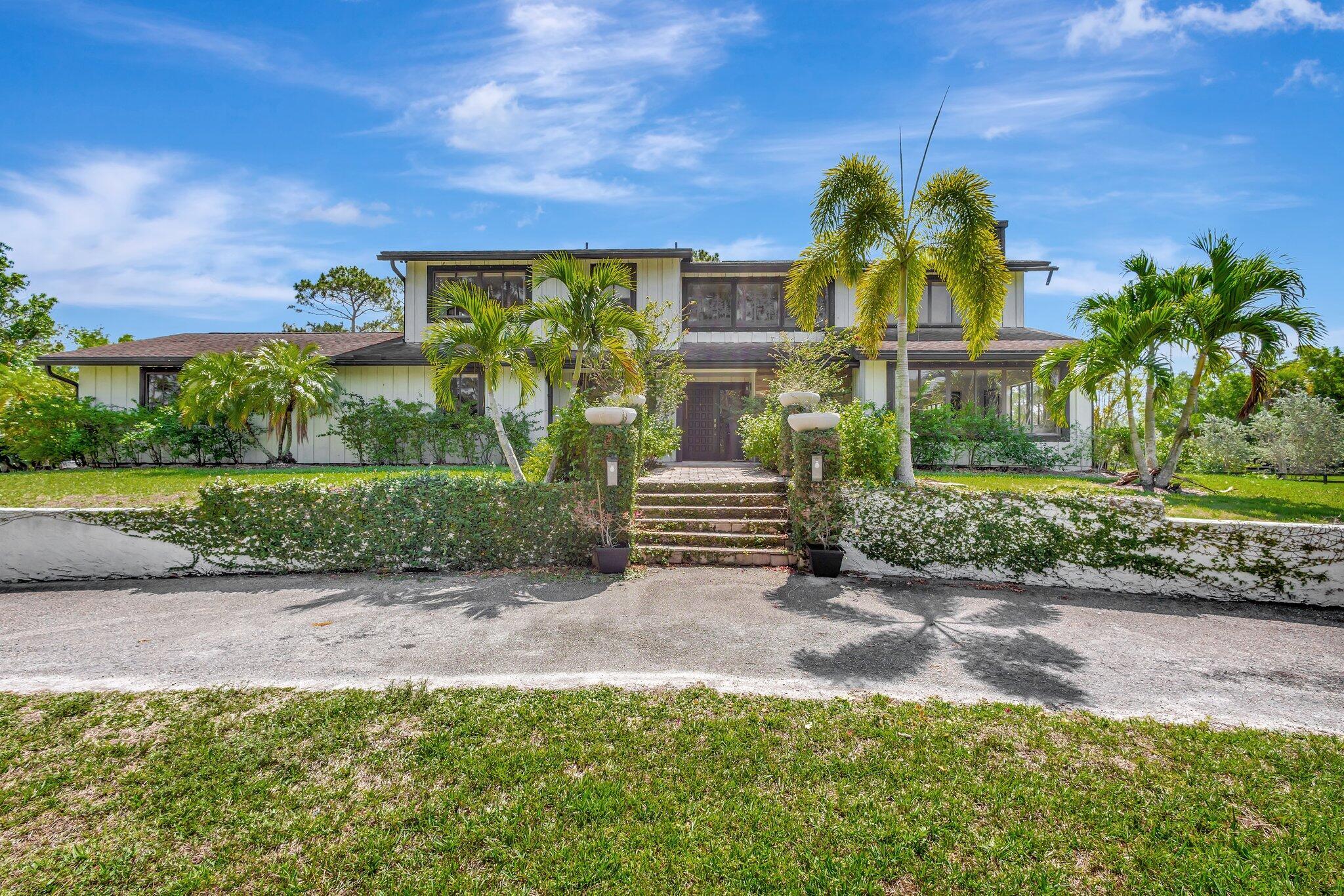 5446 Reynolds Road Lake Worth, FL 33449 - Photo 2 of 57 a view of a garden with a building in the background