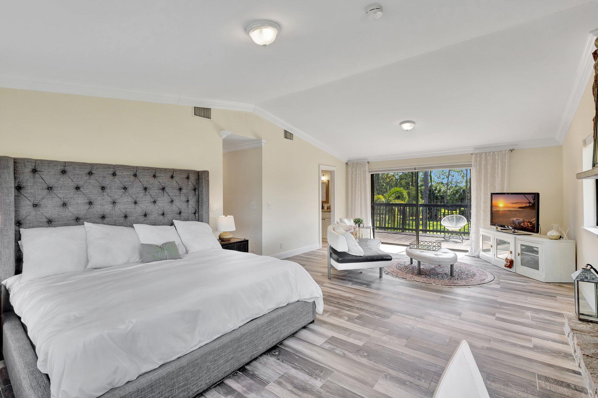 5446 Reynolds Road Lake Worth, FL 33449 - Photo 23 of 57 a bedroom with a large bed and a flat tv screen on dresser