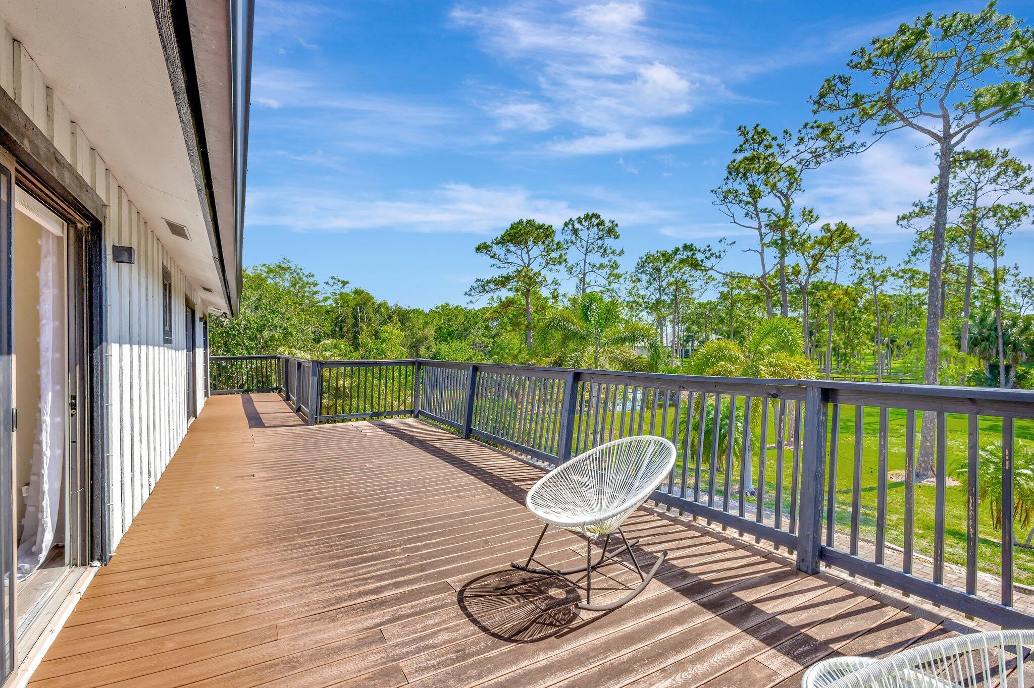 5446 Reynolds Road Lake Worth, FL 33449 - Photo 26 of 57 a balcony with wooden floor table and chairs