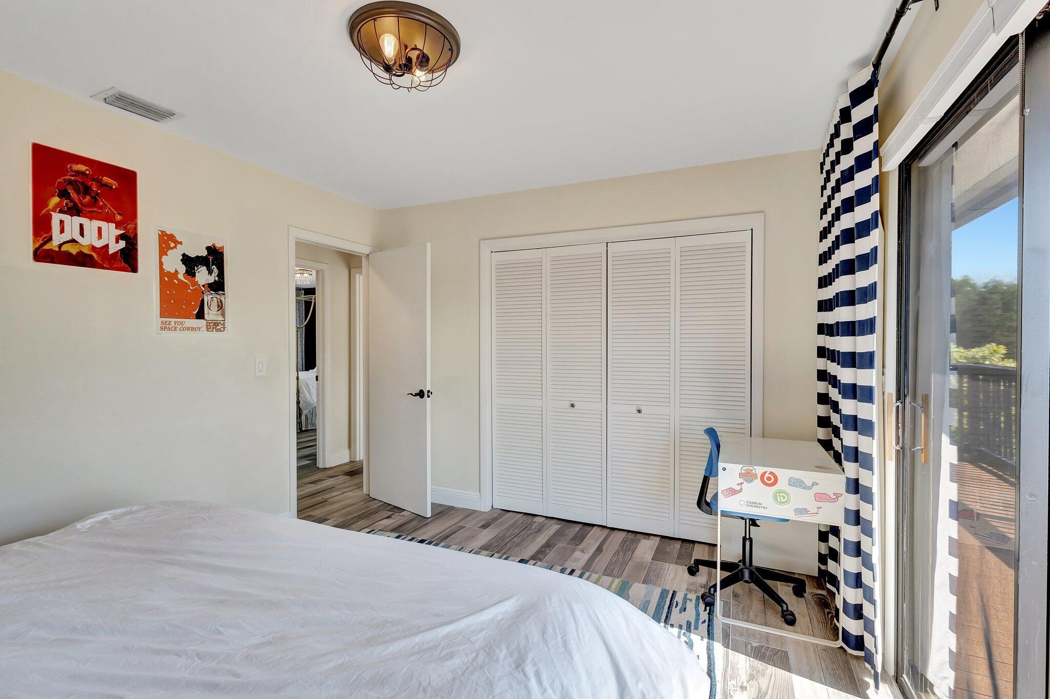 5446 Reynolds Road Lake Worth, FL 33449 - Photo 33 of 57 a bedroom with a bed and a chandelier