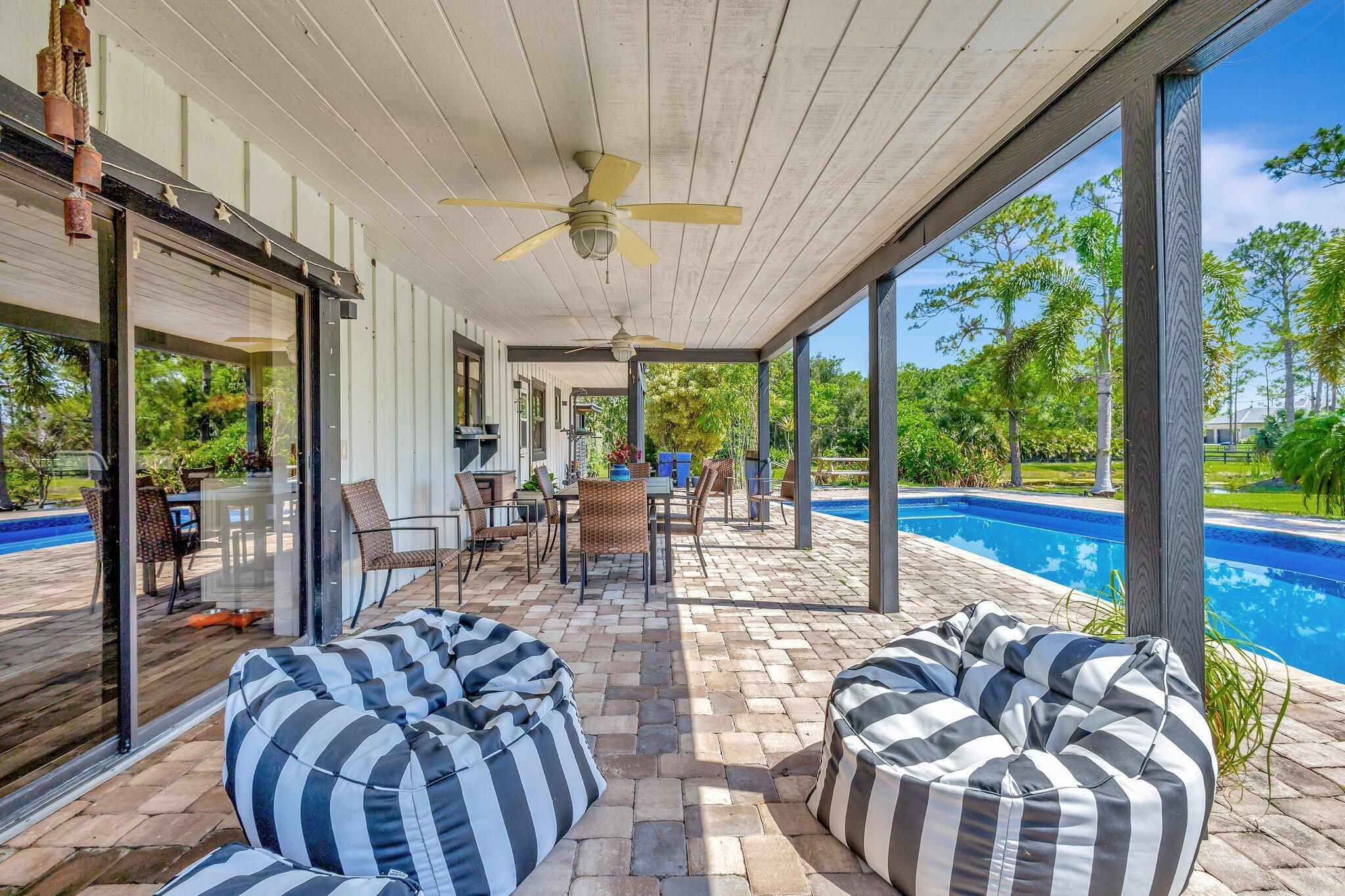 5446 Reynolds Road Lake Worth, FL 33449 - Photo 36 of 57 a view of a dining room with furniture large windows and wooden floor