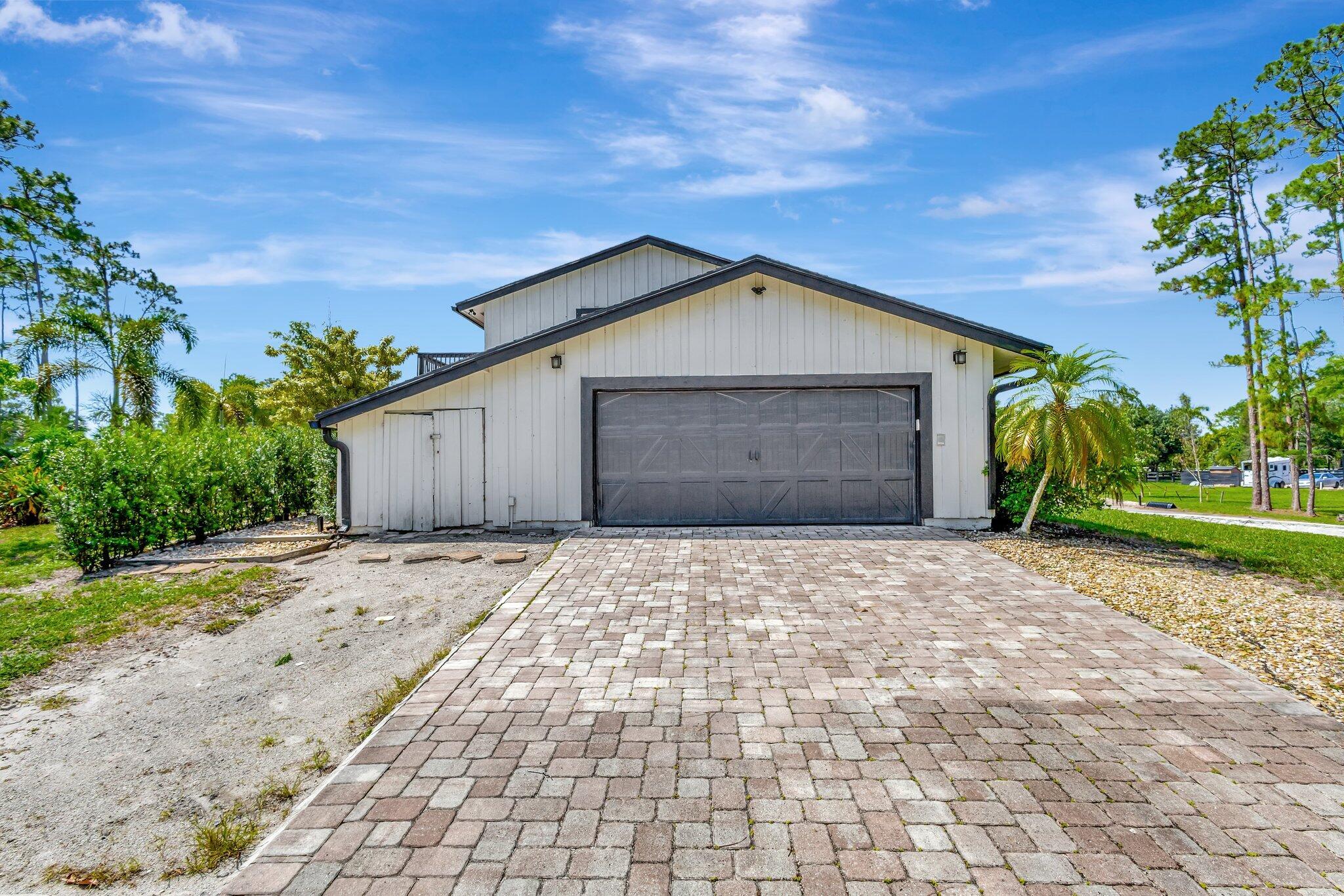 5446 Reynolds Road Lake Worth, FL 33449 - Photo 44 of 57 a front view of a house with a yard and garage