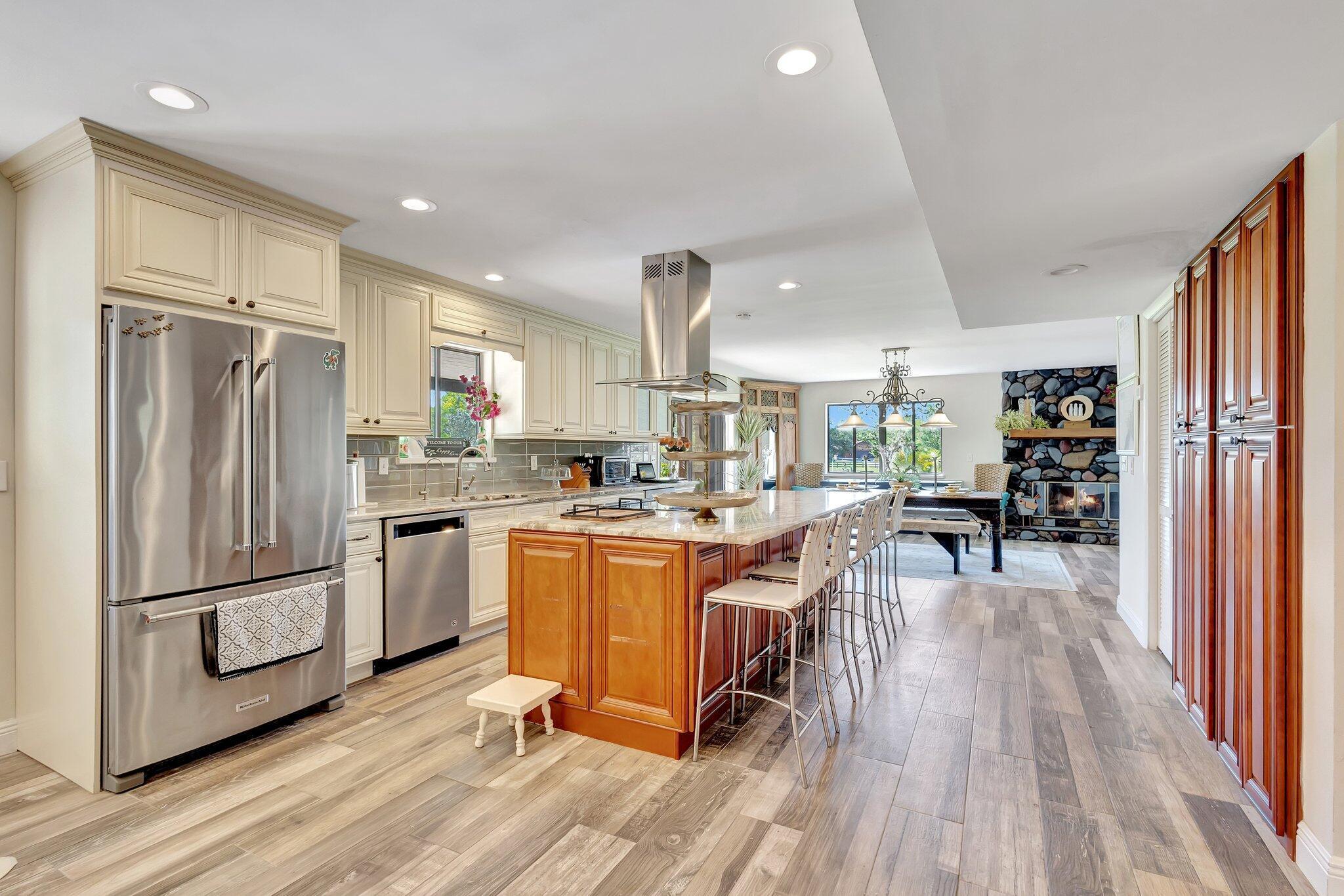5446 Reynolds Road Lake Worth, FL 33449 - Photo 10 of 57 a kitchen with stainless steel appliances granite countertop a refrigerator oven a sink dishwasher and white cabinets with wooden floor