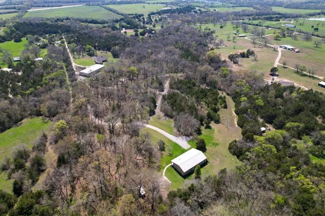 an aerial view of a house with a yard and a swimming pool