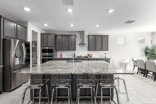 a kitchen with granite countertop kitchen island stainless steel appliances a sink stove and cabinets