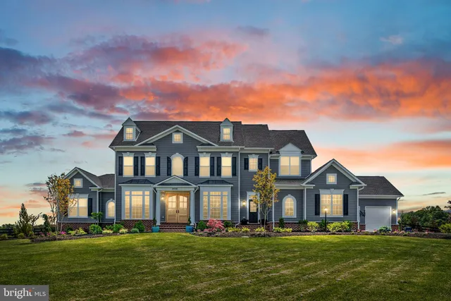 a front view of a house with a garden and trees